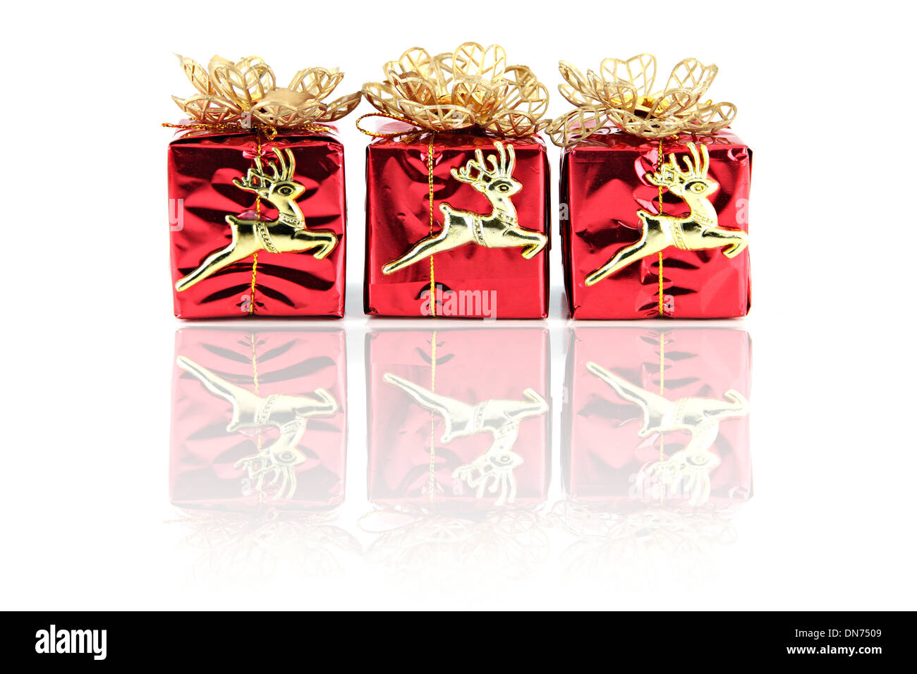 Red gift box with golden Reindeer attached. Stock Photo