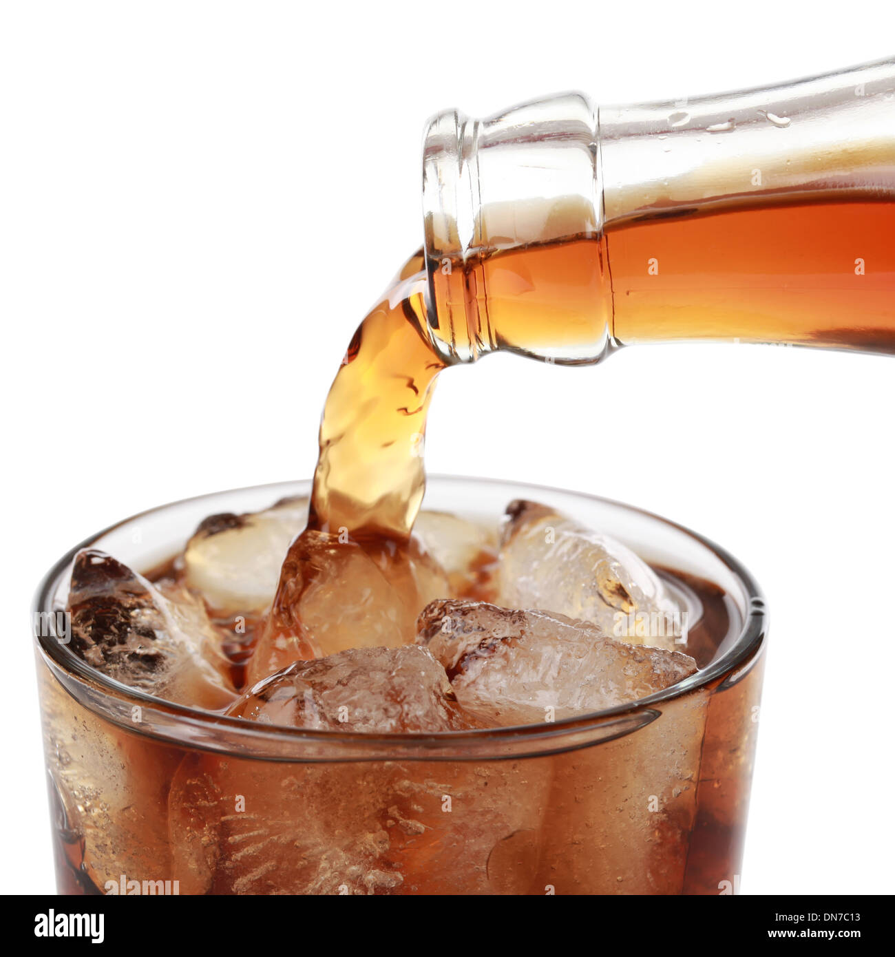Cola is pouring from a bottle into a glass, isolated on white Stock ...