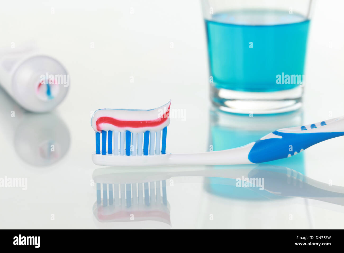 Toothpaste on a toothbrush and rinse for mouth in a bathroom Stock