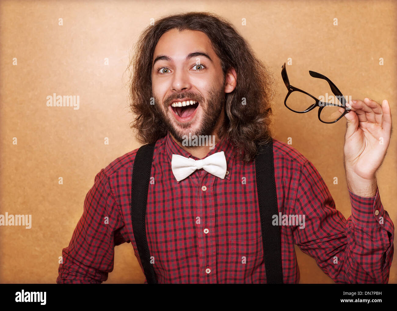 Young handsome man   keeps stylish glasses and rejoices that the idea came to him Stock Photo