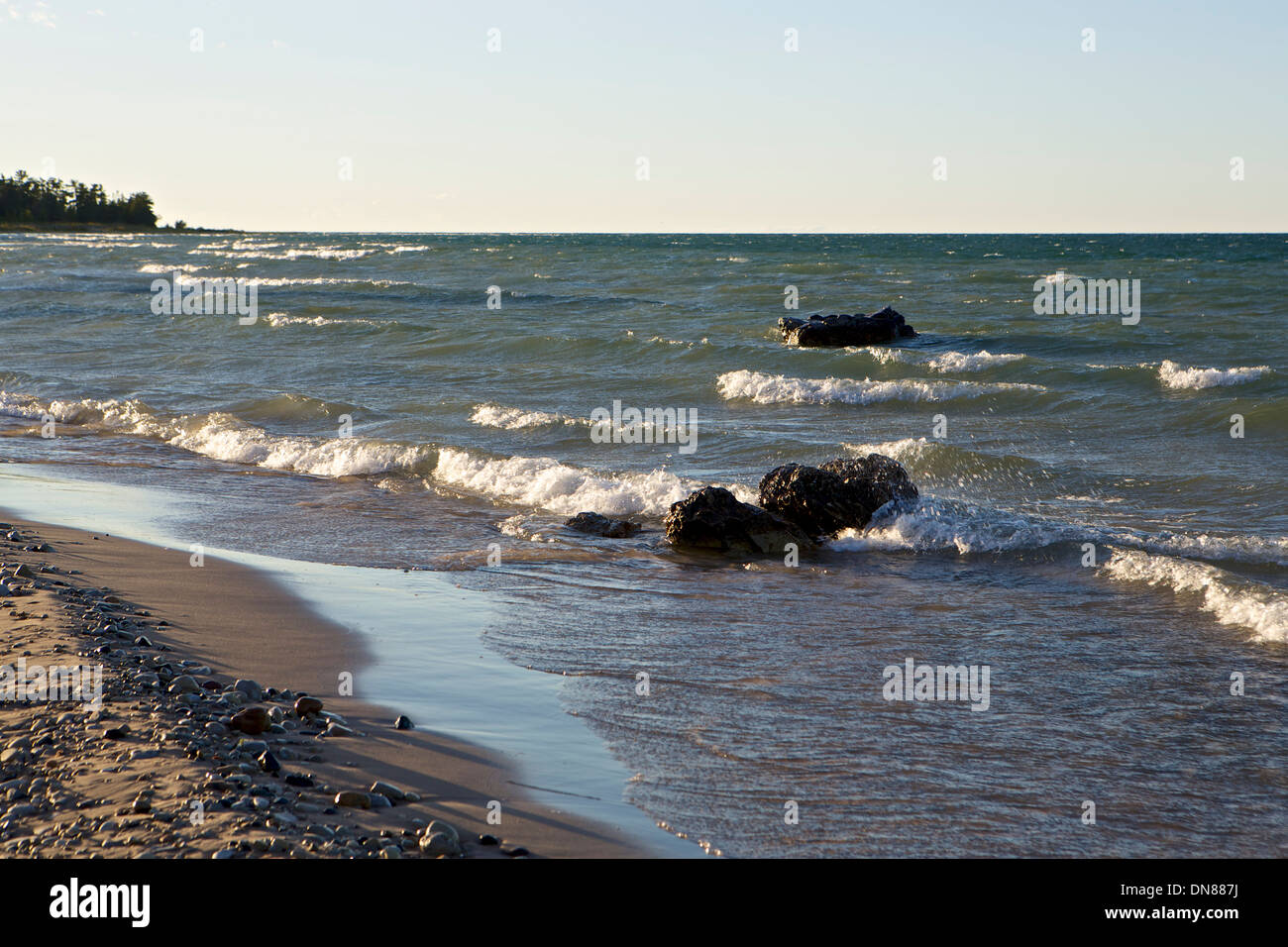 Rocks jut out of the water in Lake Huron near the beach in northern Michigan Stock Photo