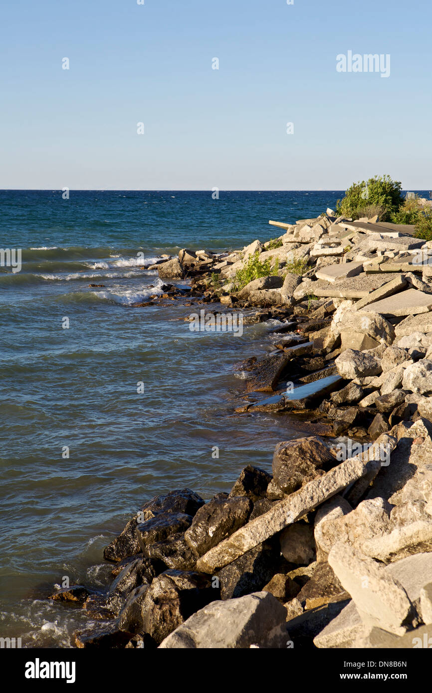 Broken slabs of concrete form a breakwall into Lake Huron at Rogers City Harbor in Michigan Stock Photo