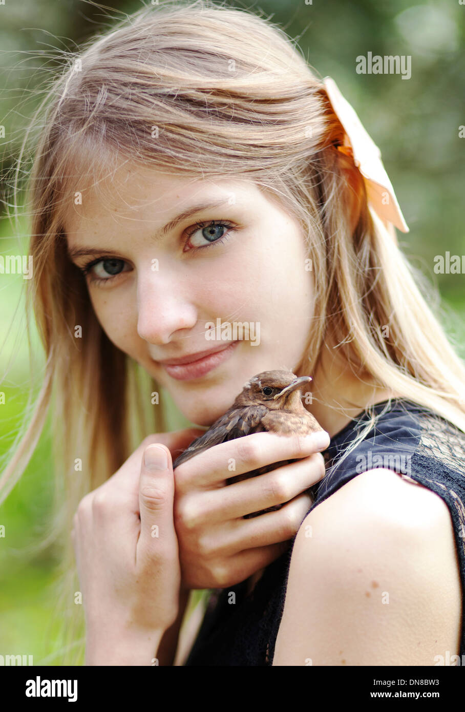 Girl with young bird on shoulder Stock Photo