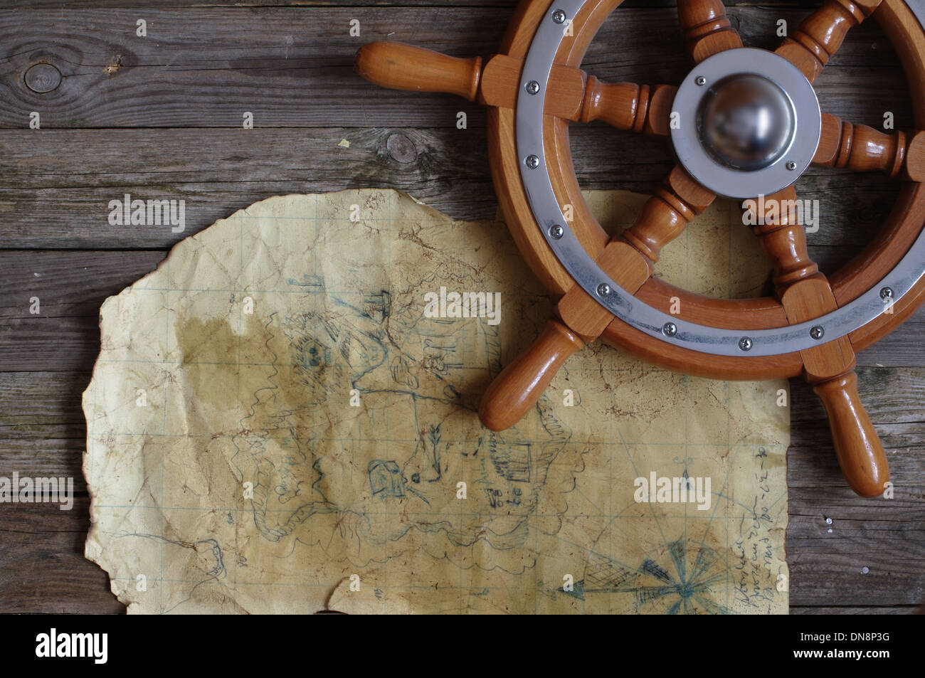 map and the steering wheel on background of old boards Stock Photo