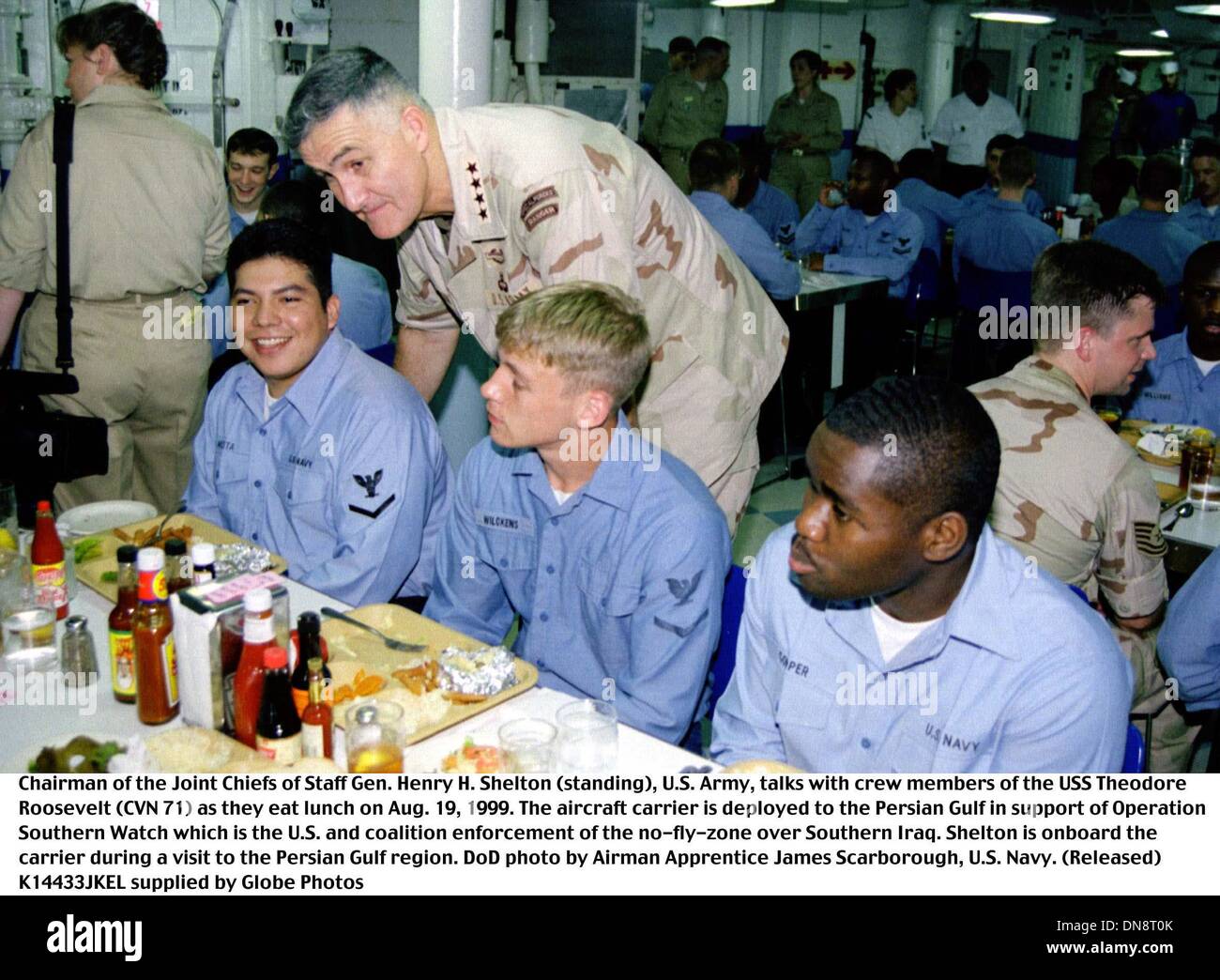 Aug. 19, 1999 - 990819-N-2003S-002..Chairman of the Joint Chiefs of Staff Gen. Henry H. Shelton (standing), U.S. Army, talks with crew members of the USS Theodore Roosevelt (CVN 71) as they eat lunch on Aug. 19, 1999.  The aircraft carrier is deployed to the Persian Gulf in support of Operation Southern Watch which is the U.S. and coalition enforcement of the no-fly-zone over South Stock Photo