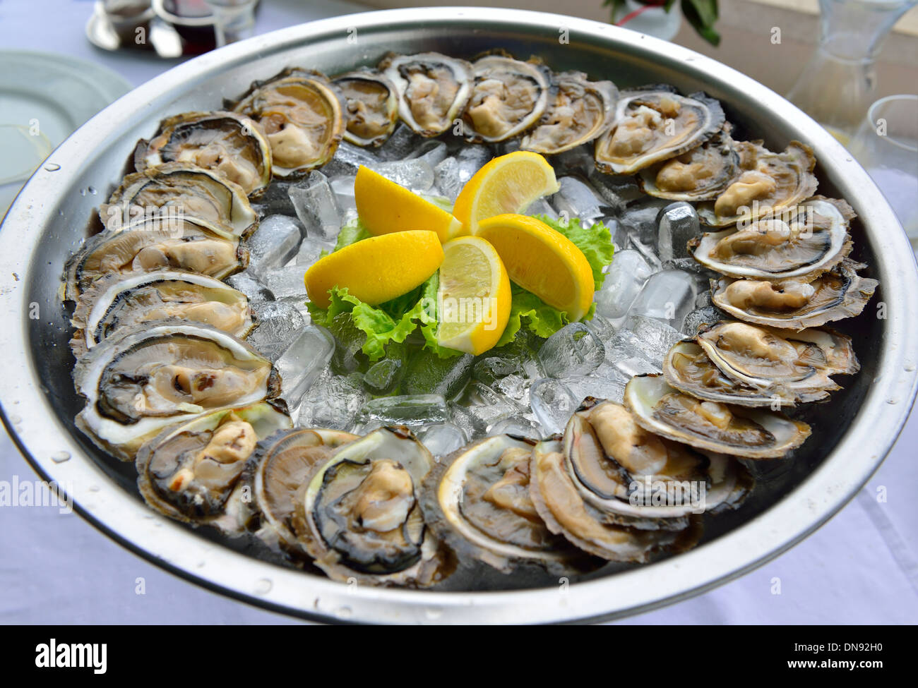 A dish of two dozen freshly served oysters in the famous Croatian waterside Bota Sare Restaurant, at Mali Ston, Croatia Stock Photo