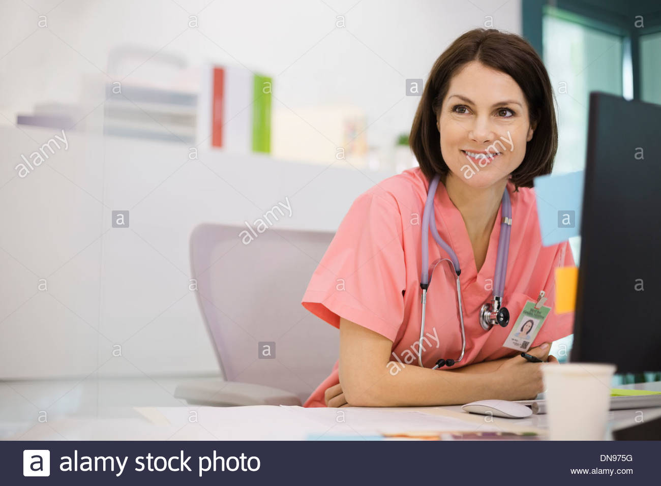 Female nurse sitting at desk Stock Photo Alamy
