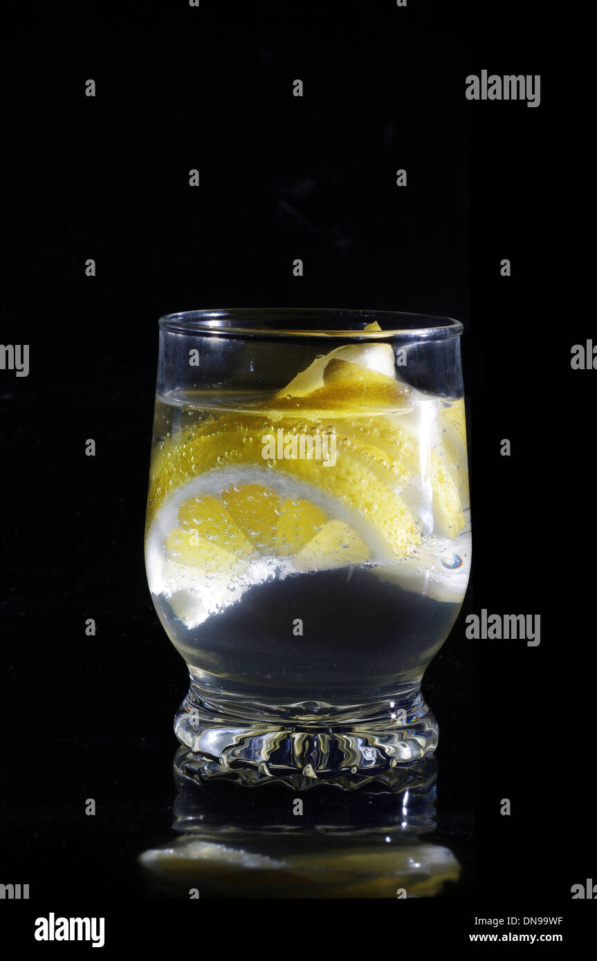 water with lemon in glass on a black background Stock Photo