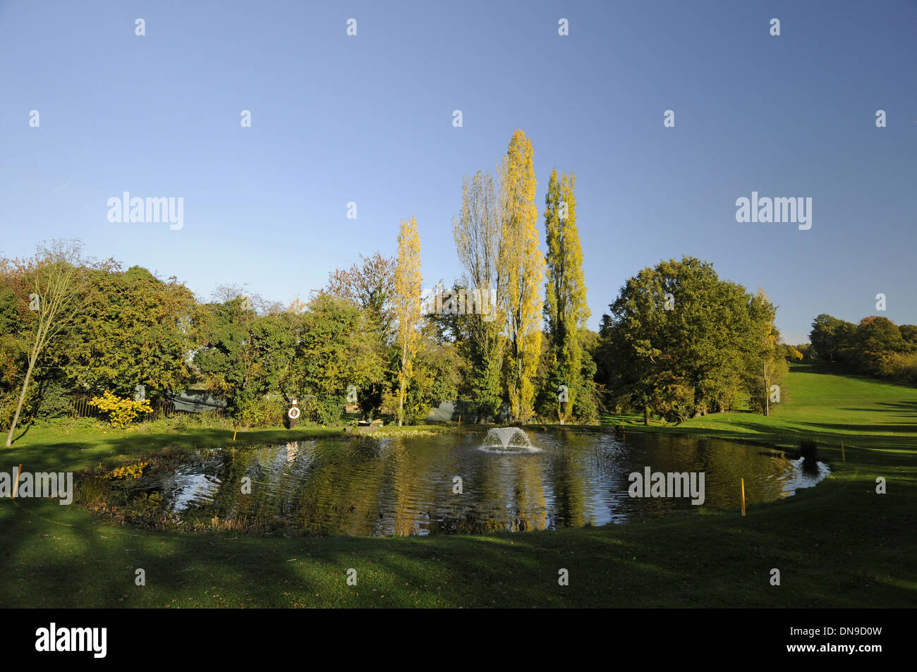 Sundridge Park Golf Club - View from Fairway over Pond with Fountain to 18th Hole and Tee with colourful Autumn Trees Stock Photo