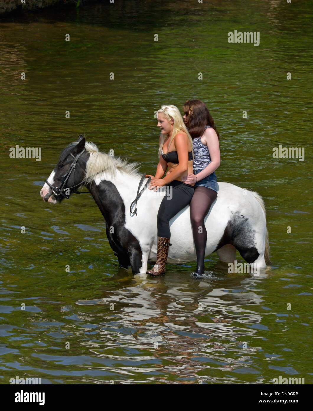 gypsy-traveller-girls-riding-horse-in-river-eden-appleby-horse-fair