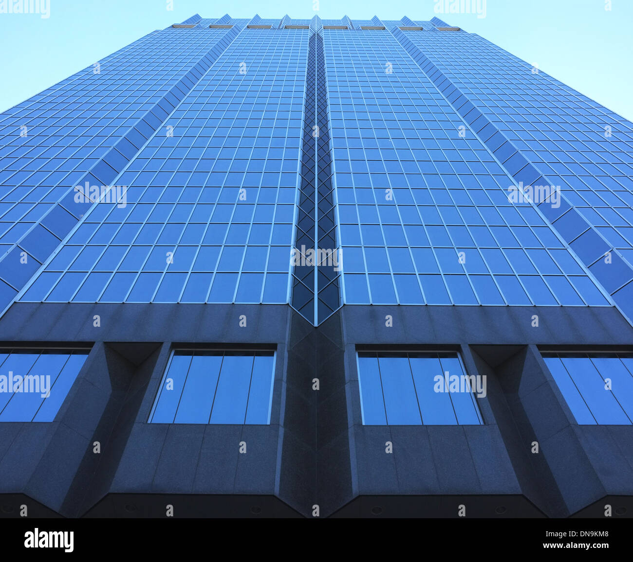 A low angled shot looking up at a tall glass skyscraper in Downtown London Ontario - Canada. Stock Photo