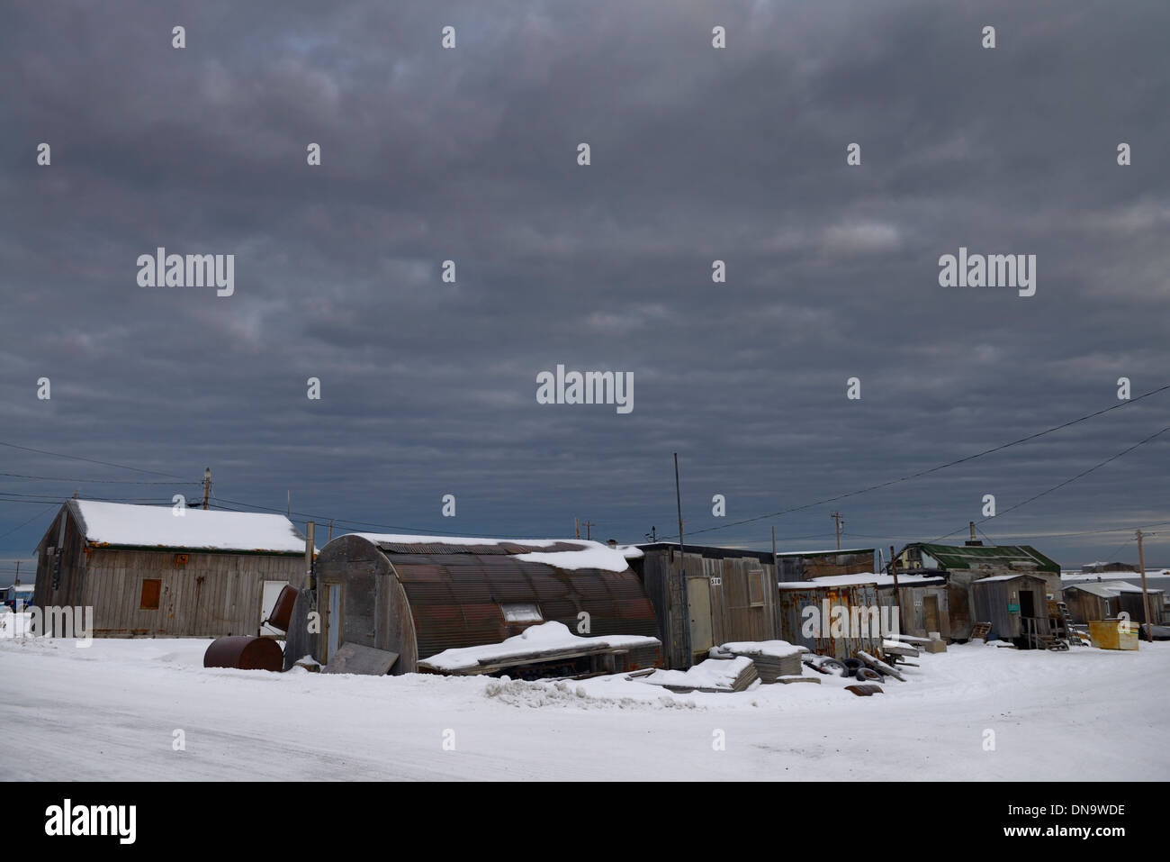 Dark clouds over storage sheds and houses in the Eskimo Inupiat village of Kaktovik Alaska on the Beaufort Sea Stock Photo