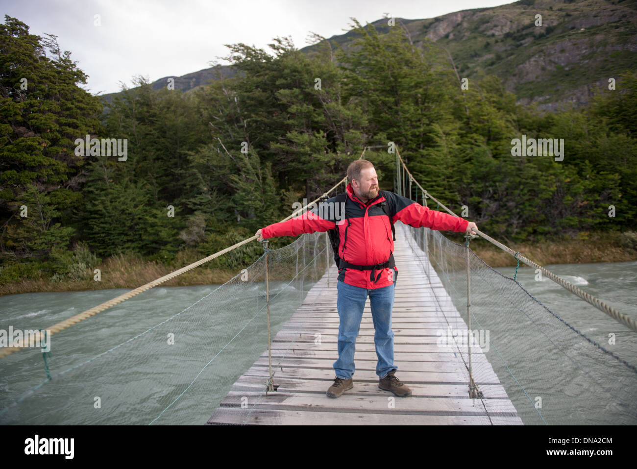 Tourist climbing bridge in Torres del Paine National Park, Chile Stock Photo