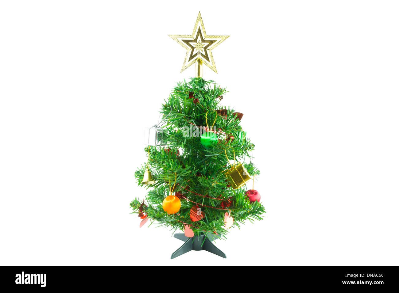 Christmas tree is ornamented with gold and silver gift box, heart red ribbon, orange and green Christmas ball, bell & gold star Stock Photo