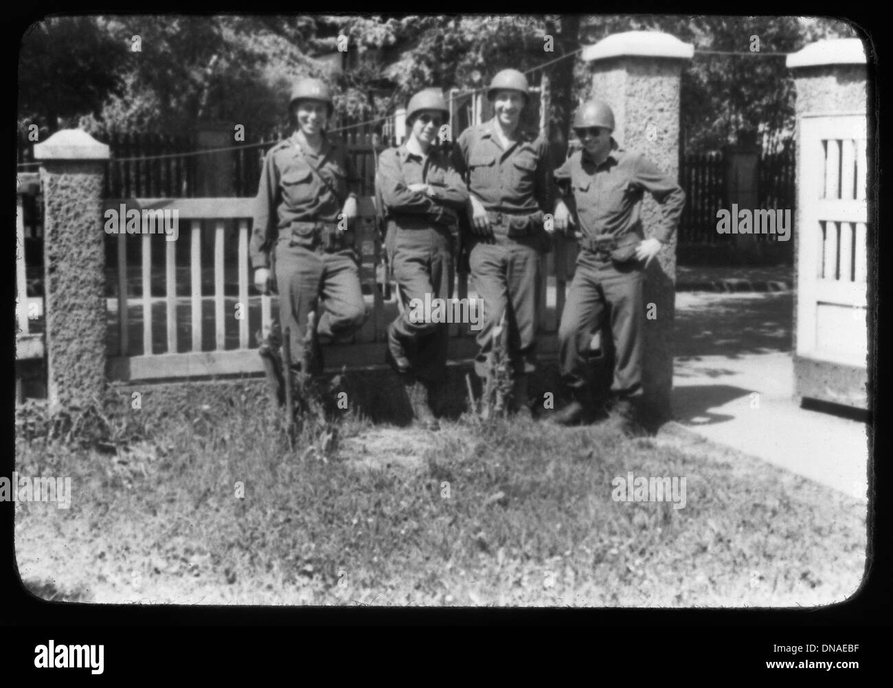 Four Soldiers Leaning Against Fence, Portrait, WWII, Third Army Division, US Army Military, Europe, 1943 Stock Photo