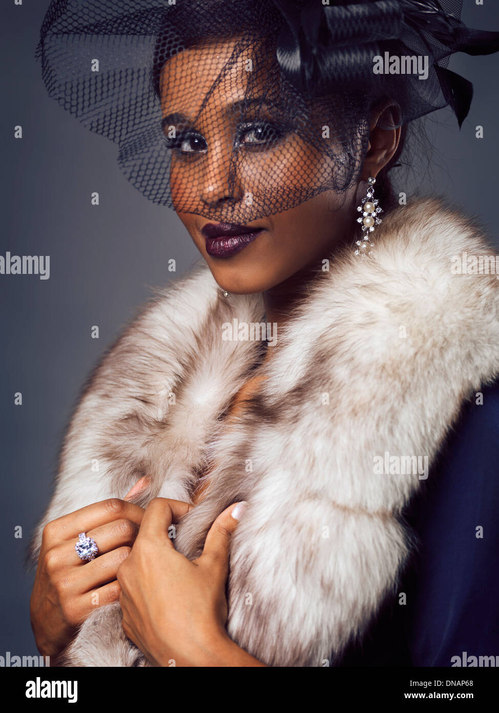 License available at MaximImages.com - Beauty portrait of a smiling young black woman wearing fur and black veil covering her face Stock Photo