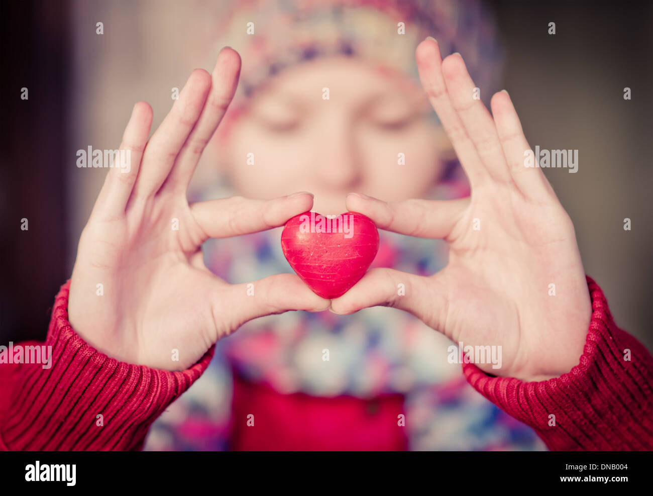 Heart shape love symbol in woman hands with face on background Valentines Day romantic greeting people relationship concept Stock Photo