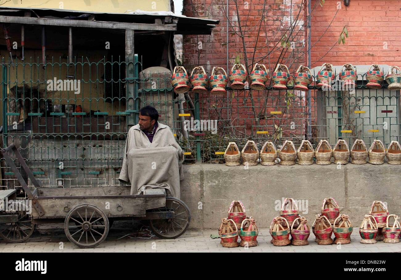 Srinagar, Indian-controlled Kashmir. 21st Dec, 2013. A Kashmiri vendor sells traditional fire-pots, or Kangris, on a cold day in Srinagar, summer capital of Indian-controlled Kashmir, Dec. 21, 2013. The 40-day harshest period of winter in Kashmir Valley, known as 'Chillai-Kalan', began on Saturday with a cold morning. Credit:  Javed Dar/Xinhua/Alamy Live News Stock Photo