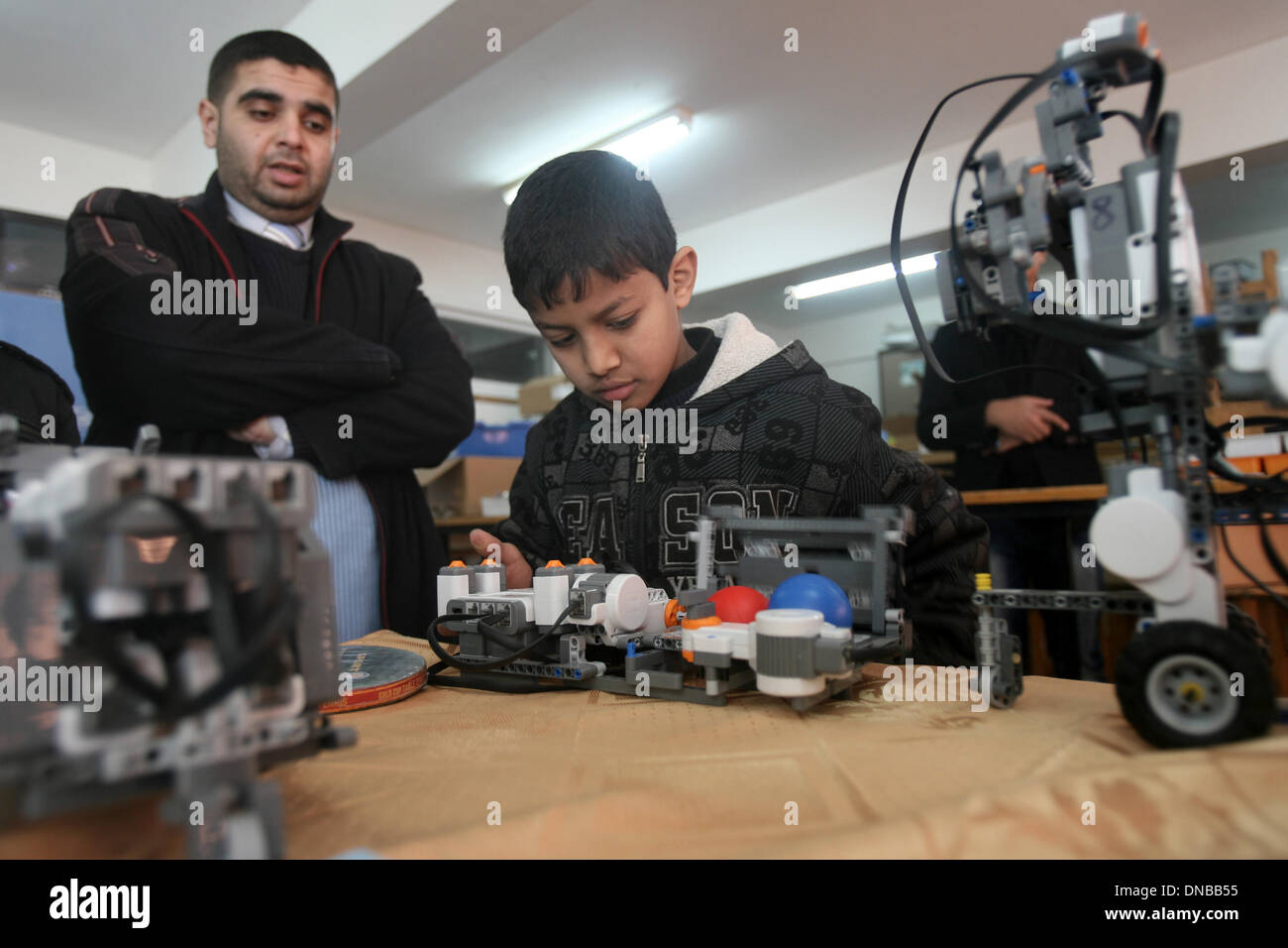 Rafah, Gaza Strip, Palestinian Territory. 21st Dec, 2013. Palestinian school students take part in a robotics workshop organised by the United Nations Relief and Works Agency for Palestine Refugees (UNRWA) at a school in Rafah town, in the southern Gaza Strip, on December 21, 2013 Credit:  Eyad Al Baba/APA Images/ZUMAPRESS.com/Alamy Live News Stock Photo