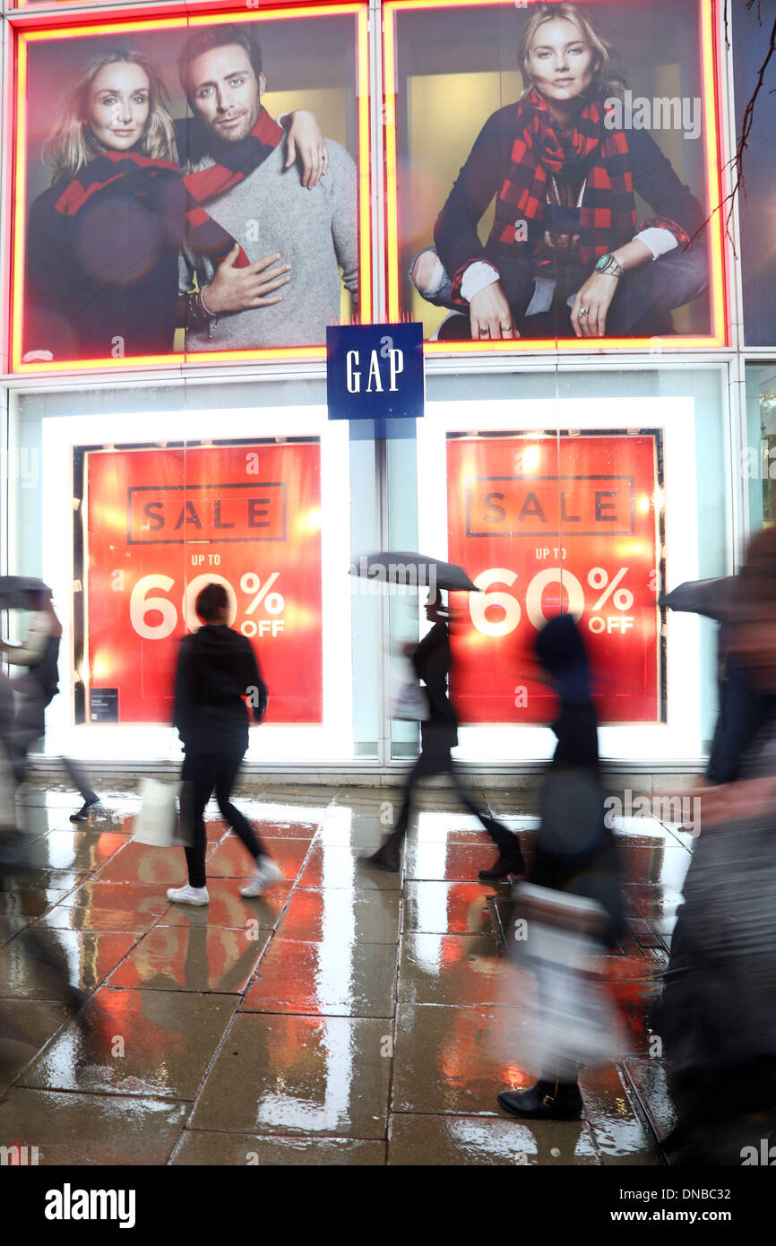 Shoppers are seen walking past H&M window display with a large SALE sign.  Last minute Christmas shoppers take advantage of pre-Christmas bargains at  Oxford Street in London. Fewer shoppers have been reported