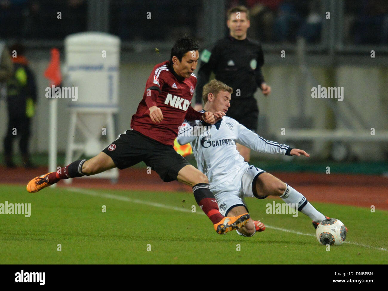 Nuremberg, Germany. 21st Dec, 2013. Nuremberg's Makoto Hasabe (L) vies for the ball with Schalke's Maximilian Meyer during the German Bundesliga match between FC Nuremberg and FC Schalke 04 at Grundig Stadium in Nuremberg, Germany, 21 December 2013. Photo: TIMM SCHAMBERGER (ATTENTION: Due to the accreditation guidelines, the DFL only permits the publication and utilisation of up to 15 pictures per match on the internet and in online media during the match.)/dpa/Alamy Live News Stock Photo
