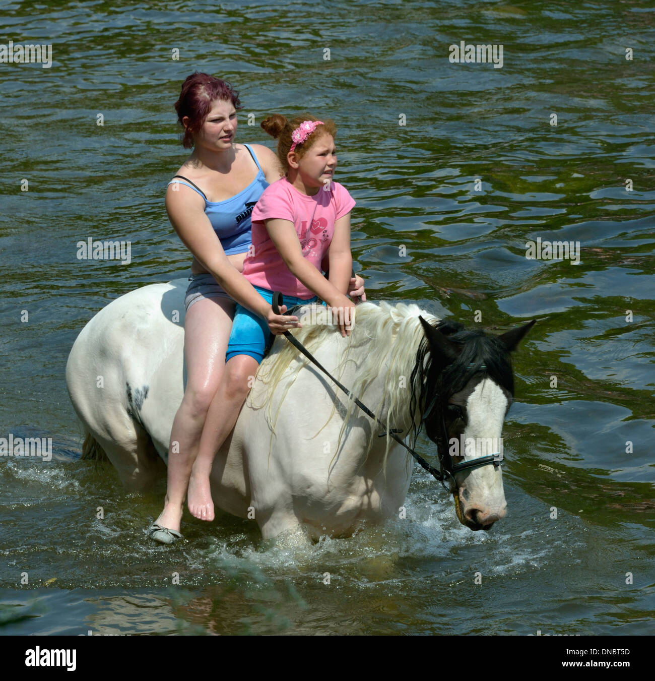 Gypsy traveller girls riding horse in River Eden. Appleby Horse Fair