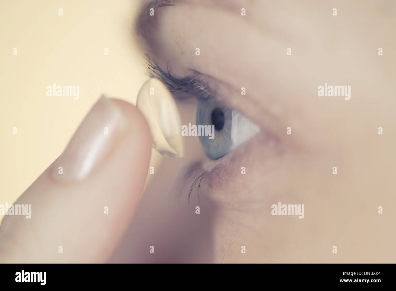 A woman applying a contact lens Stock Photo