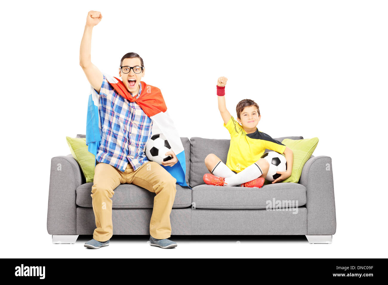 Two male sport fans seated on a sofa watching sport Stock Photo