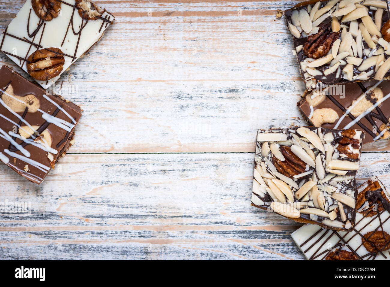 Assorted chocolate caramel bark pieces arranged on wooden background from above with copy space Stock Photo