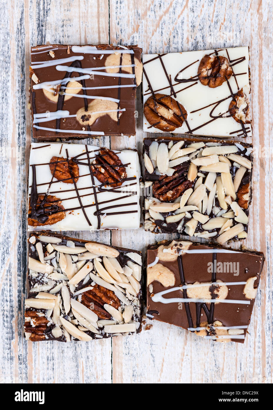 Assorted chocolate caramel bark pieces for sweet dessert arranged on wooden background, top view Stock Photo