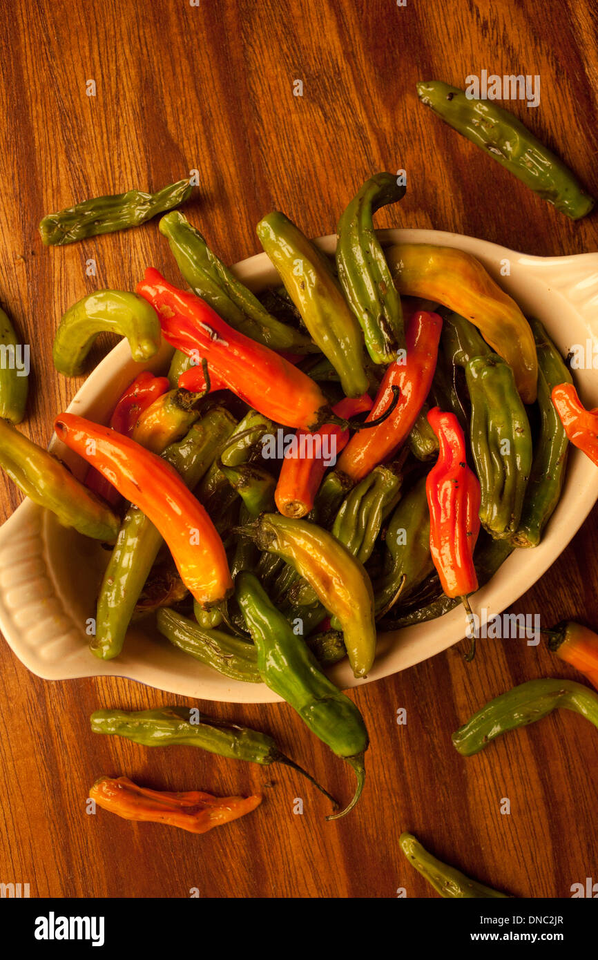 green and orange roasted peppers in white bowl overhead Stock Photo