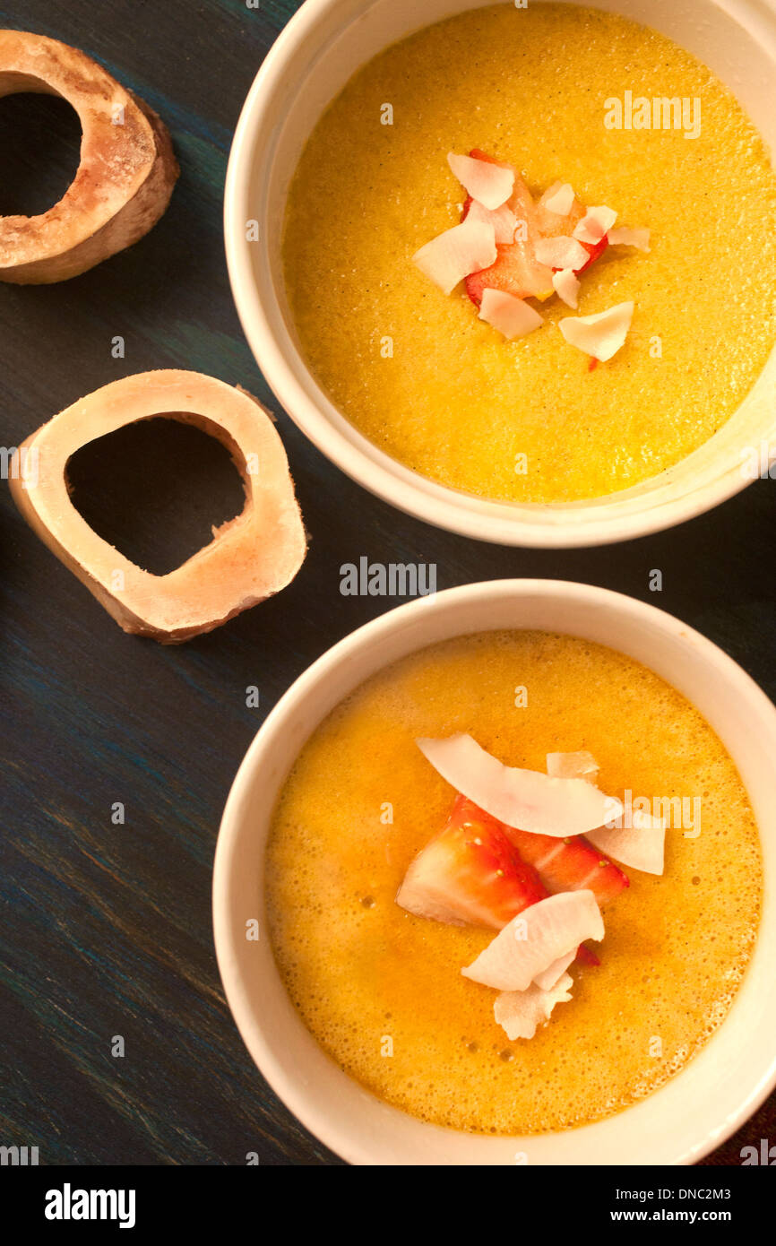 Yellow custard in white souffle dishes overhead Stock Photo