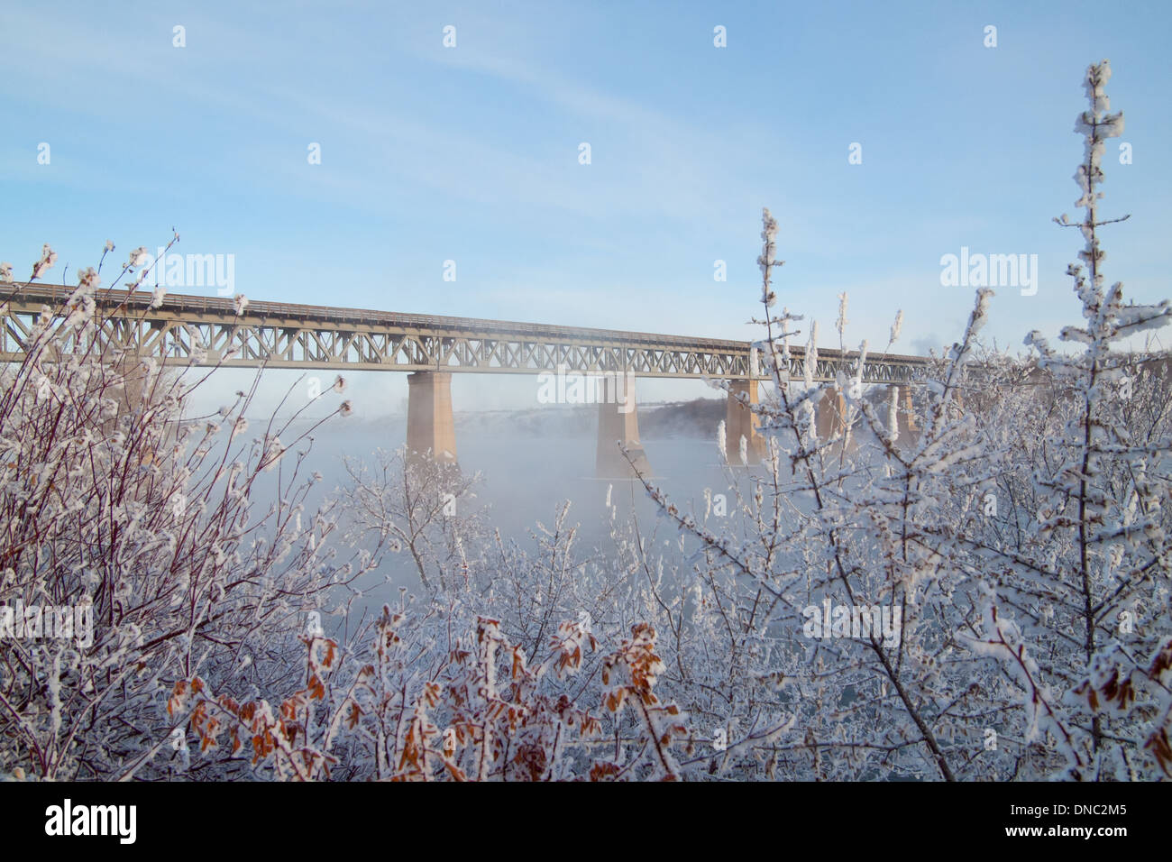 A winter view of the CPR Bridge spanning the South Saskatchewan River in Saskatoon, Saskatchewan, Canada. Stock Photo