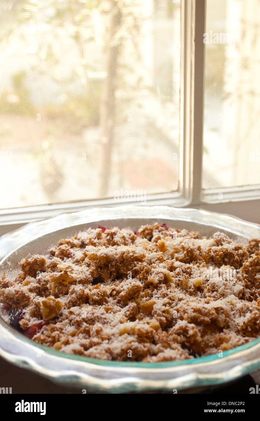 Fruit pie with crumble crust sitting by a window Stock Photo