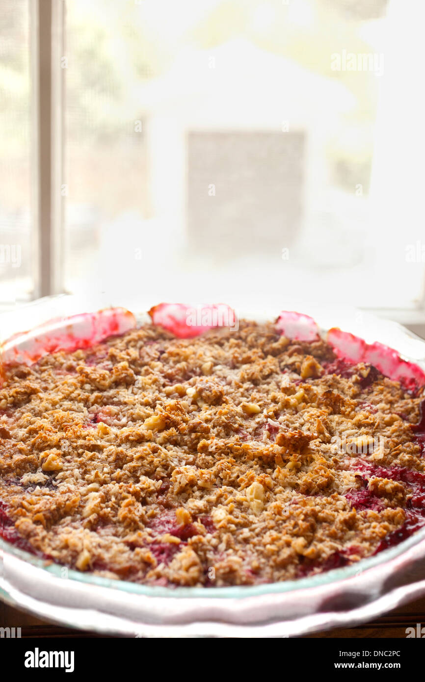 Fruit pie with crumble crust by window Stock Photo