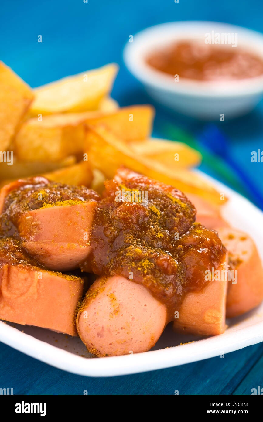 German fast food called Currywurst served with French fries on a disposable plate Stock Photo