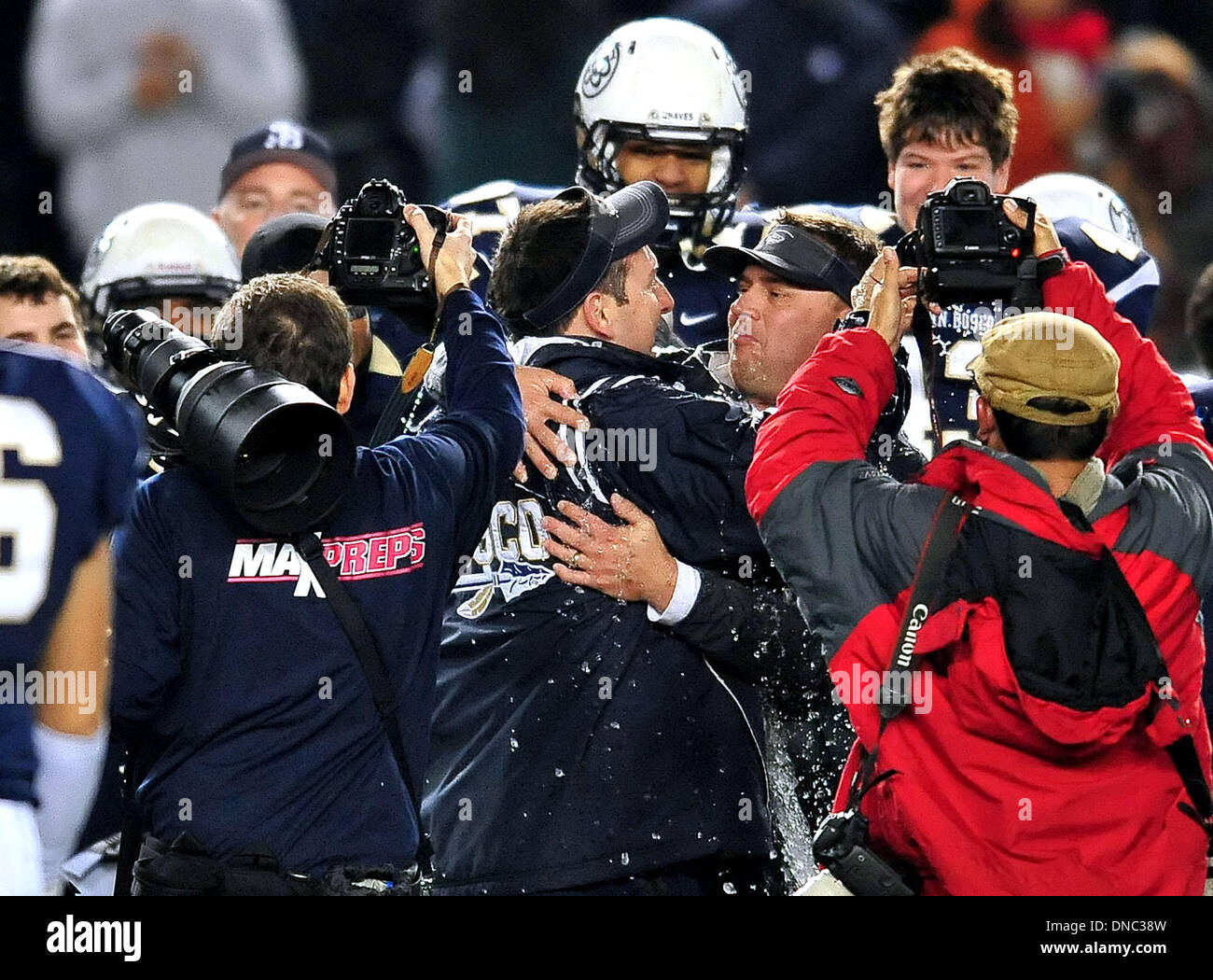 Carson, CA, . 21st Dec, 2013. Saint John Bosco Braves head coach Jason Negron embraces an assistant coach after he is is dunked by his players with water after winning the CIF Open Division California State Football Championship football game between the Concord De La Salle Spartans and the Saint John Bosco Braves at the StubHub Center in Carson, California.The Saint John Bosco Braves defeat the Concord De La Salle Spartans 20-14.Louis Lopez/CSM/Alamy Live News Stock Photo