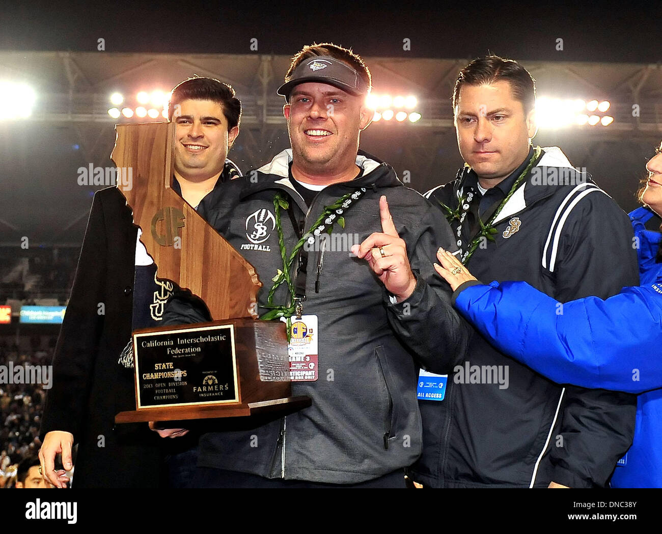Carson, CA, . 21st Dec, 2013. Saint John Bosco Braves head coach Jason Negron accepts the Championship trophy after winning the CIF Open Division California State Football Championship football game between the Concord De La Salle Spartans and the Saint John Bosco Braves at the StubHub Center in Carson, California.The Saint John Bosco Braves defeat the Concord De La Salle Spartans 20-14.Louis Lopez/CSM/Alamy Live News Stock Photo