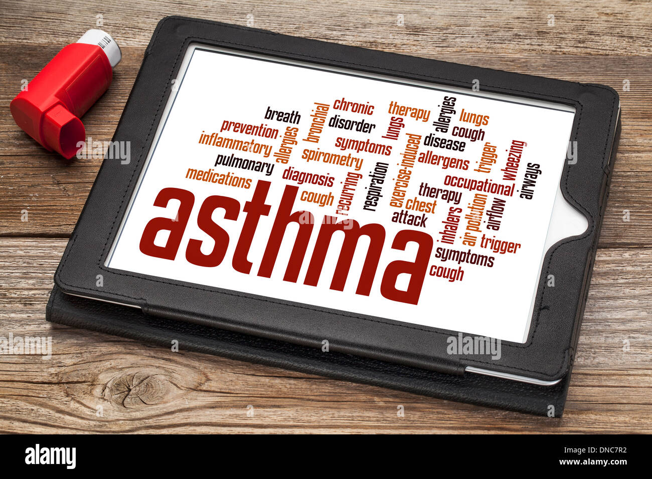 asthma word cloud on a digital tablet screen with an inhaler Stock Photo