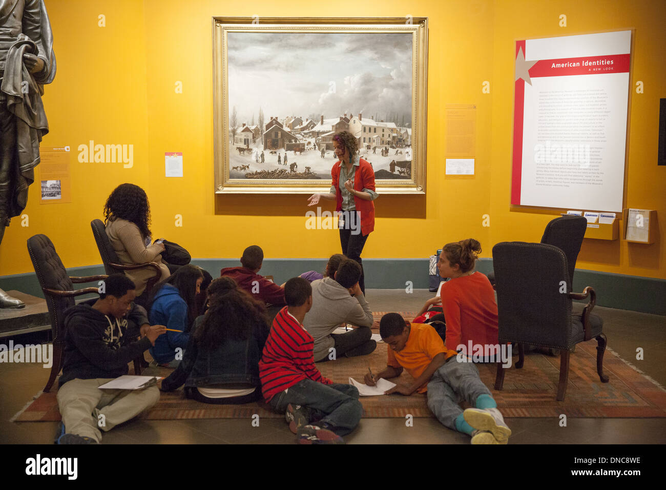 High school students learn about art on a trip to the Brooklyn Museum, Brooklyn, NY.  'Winter Scene in Brooklyn,' 1820, by Francis Guy in background. Stock Photo