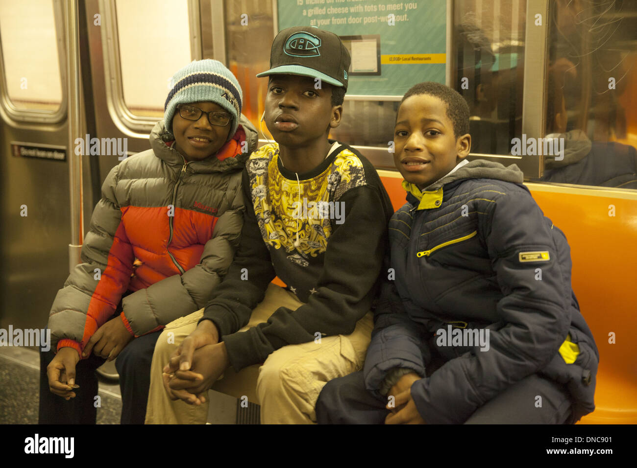 three pals ride the Q train in Crown Heights, Brooklyn, New York. Stock Photo