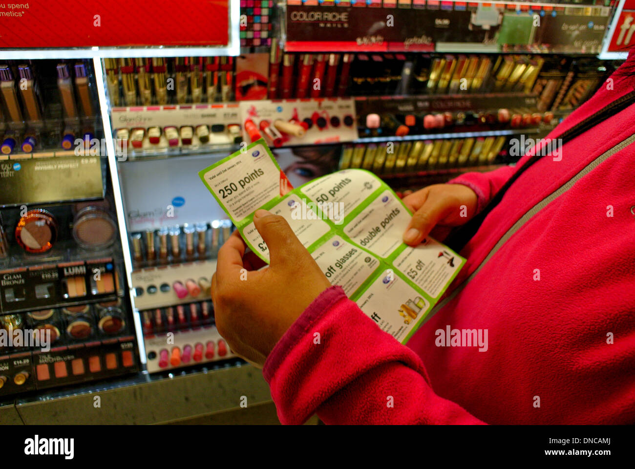 Customer looking at her Boots loyalty points discount coupon Stock Photo Alamy