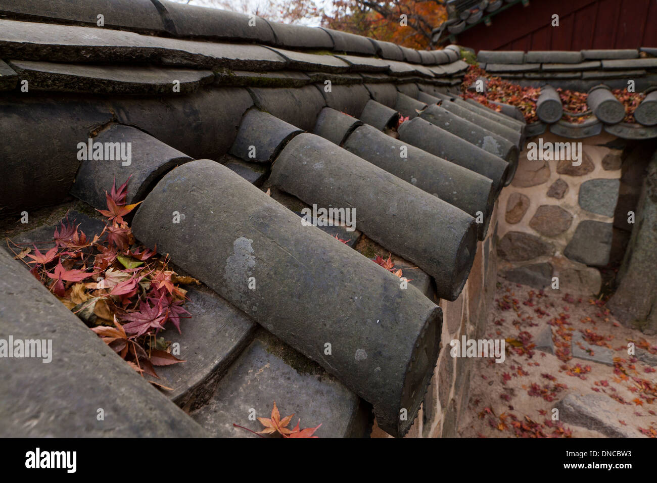 Giwa (fired clay roof tiles) used on  traditional Hanok style stone wall fence - Gyeongju, South Korea Stock Photo