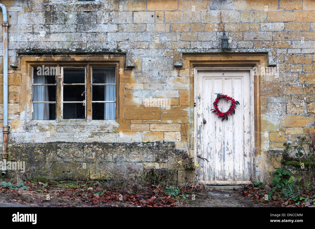 Historic Cotswold cottage with ring and peeling painted door