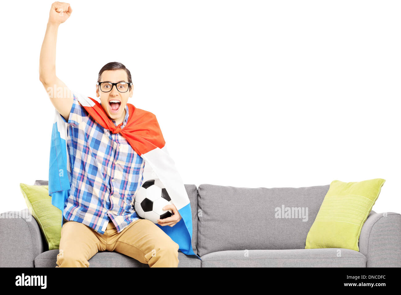Cheerful male sport fan with soccer ball and flag watching sport Stock Photo