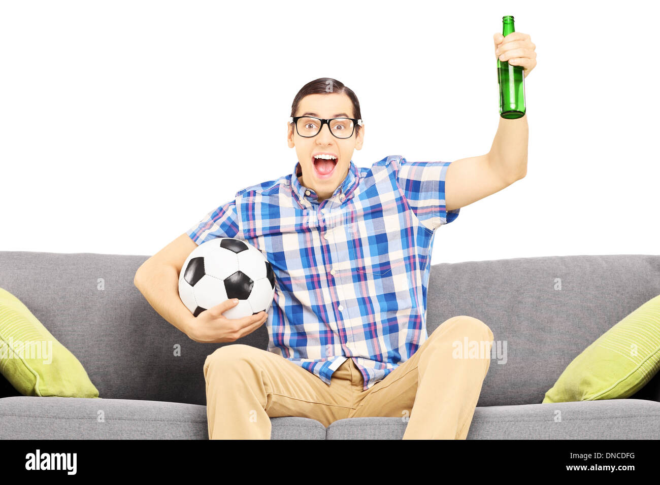 Excited male sport fan with soccer ball and beer watching sport Stock Photo