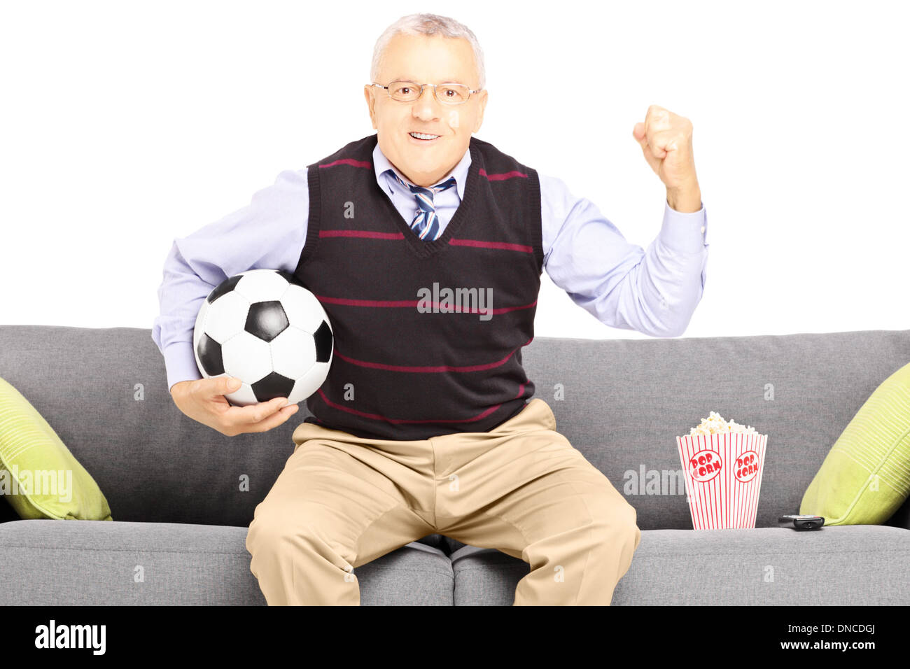 Middle aged sport fan holding a soccer ball and watching sport Stock Photo