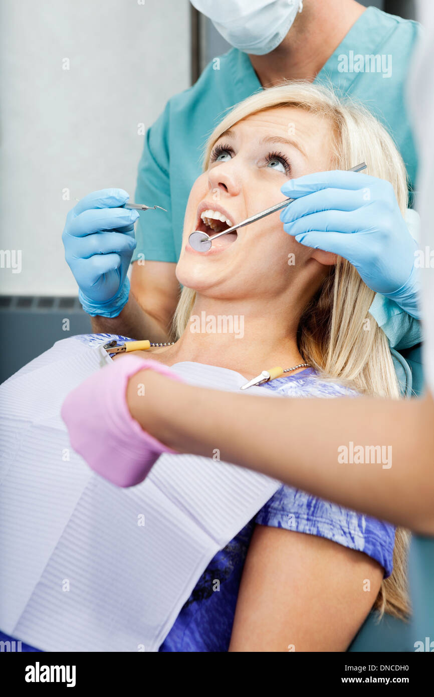 Dentists Treating A Female Patient At Clinic Stock Photo