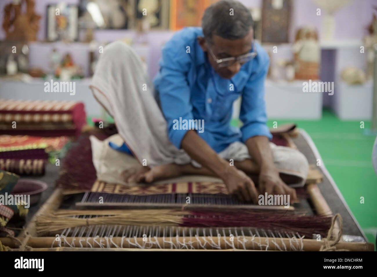 South Asian male weaver on hand loom. Stock Photo