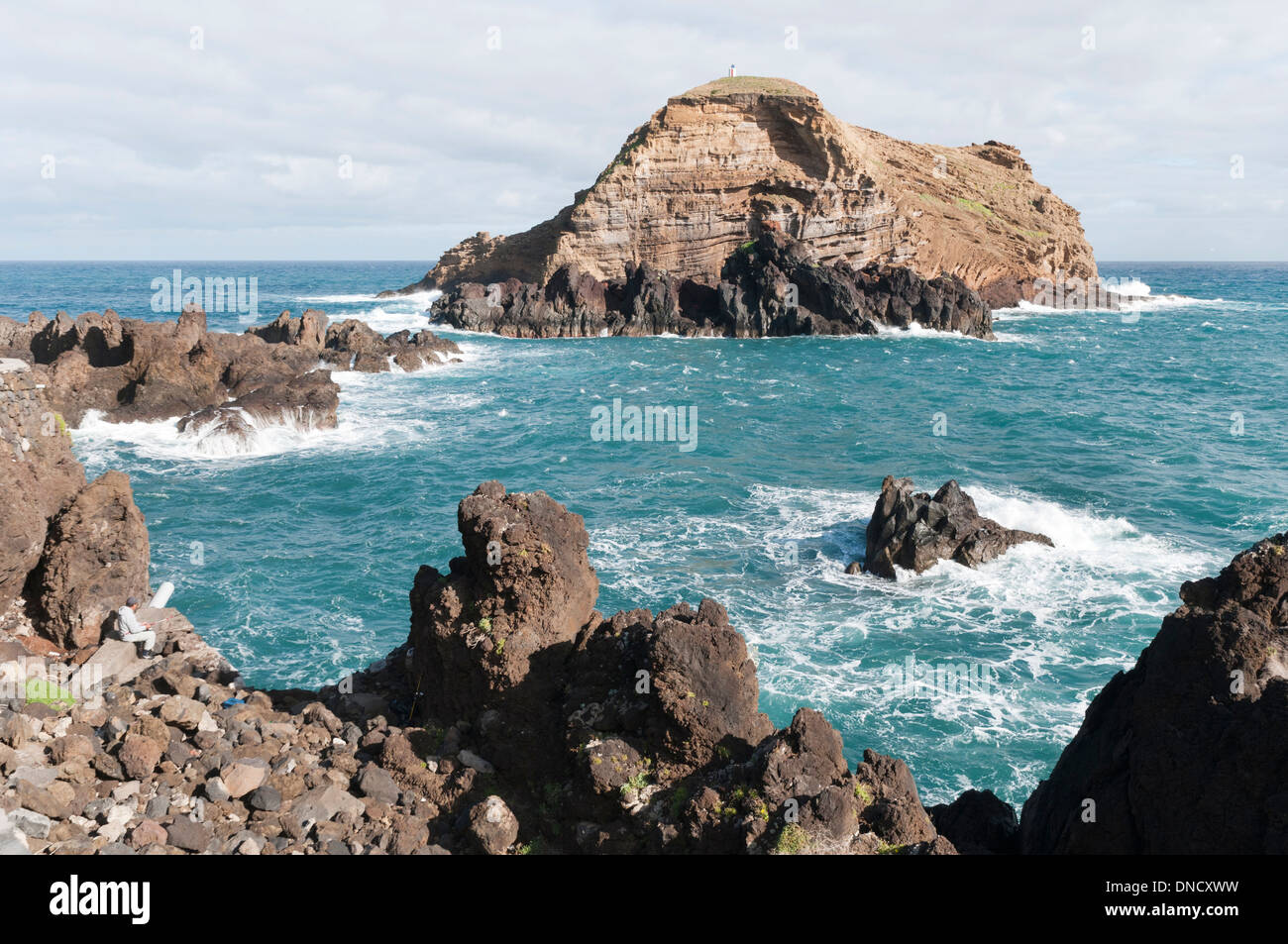 A man fishes on the headland at Porto Moniz, the most north-Westerley point of Madeira, Portugal Stock Photo